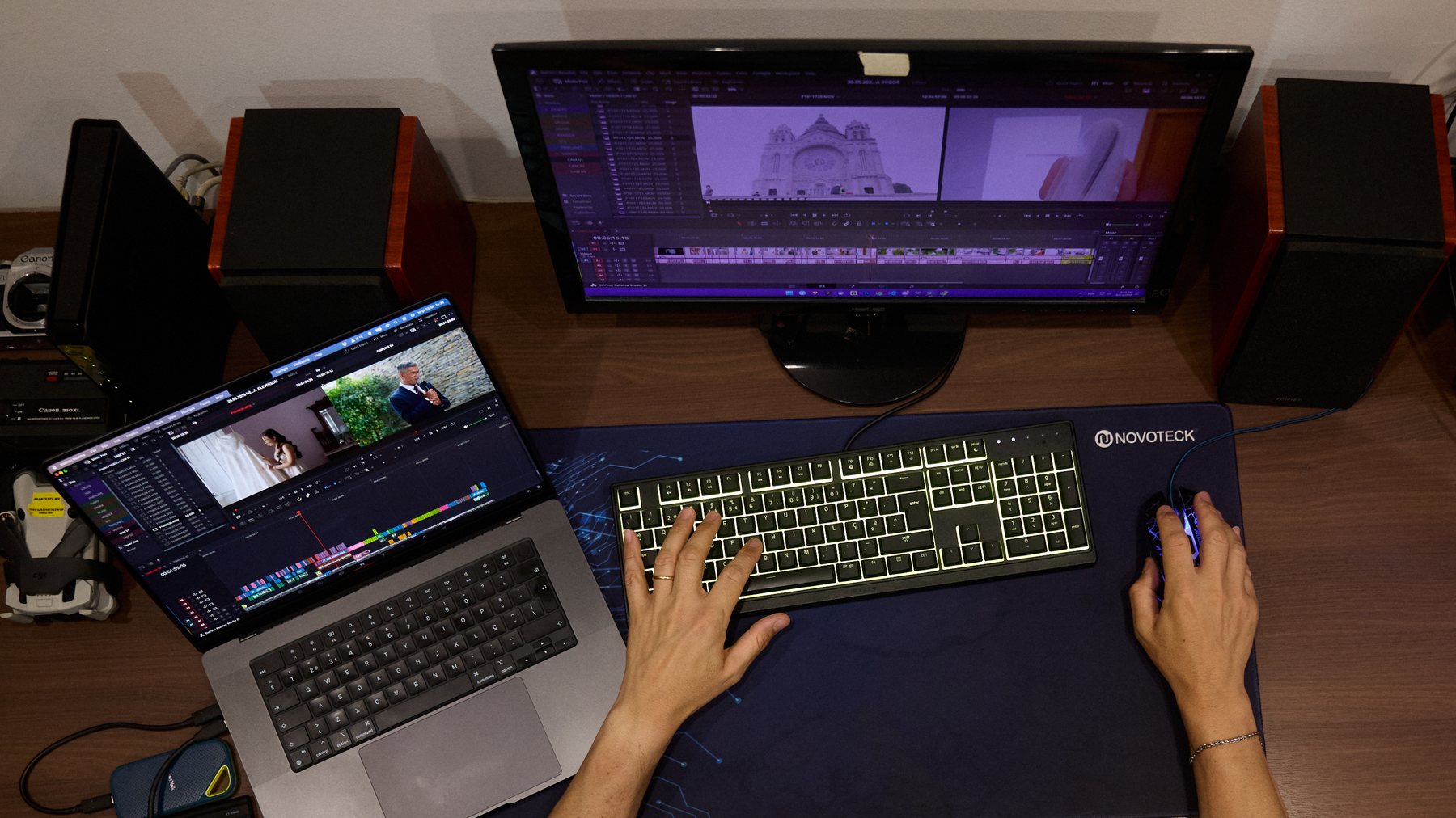 Mãos no teclado na secretária de edição, com o filme no monitor