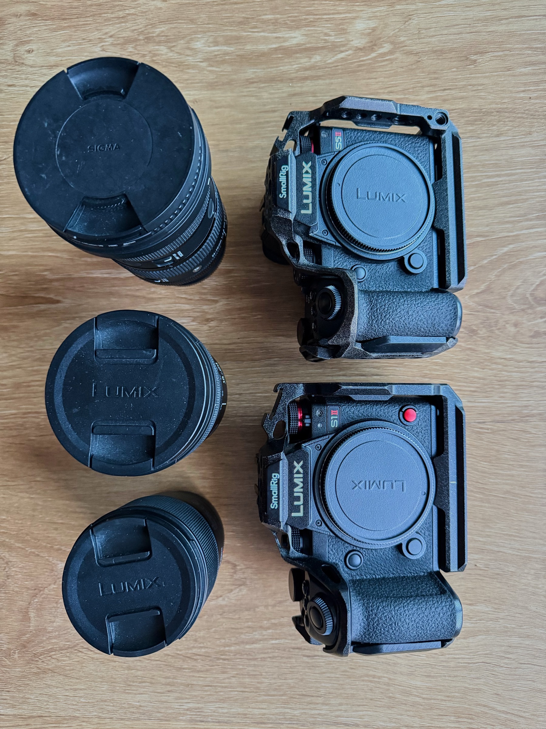Dois corpos de câmara Lumix e três lentes pousados numa mesa antes de um casamento