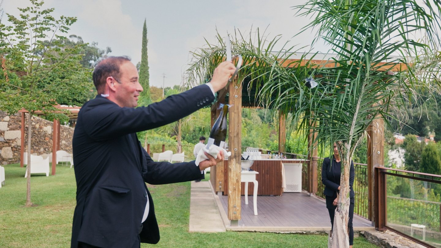 A hand pinning the pocket square on the groom's jacket