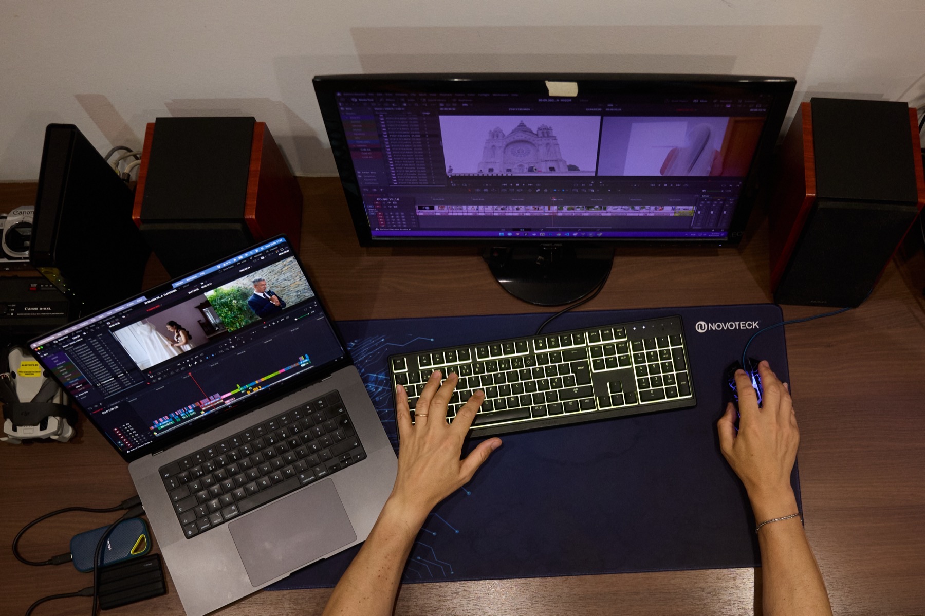 Portátil e monitor de edição com a montagem de um filme de casamento aberta