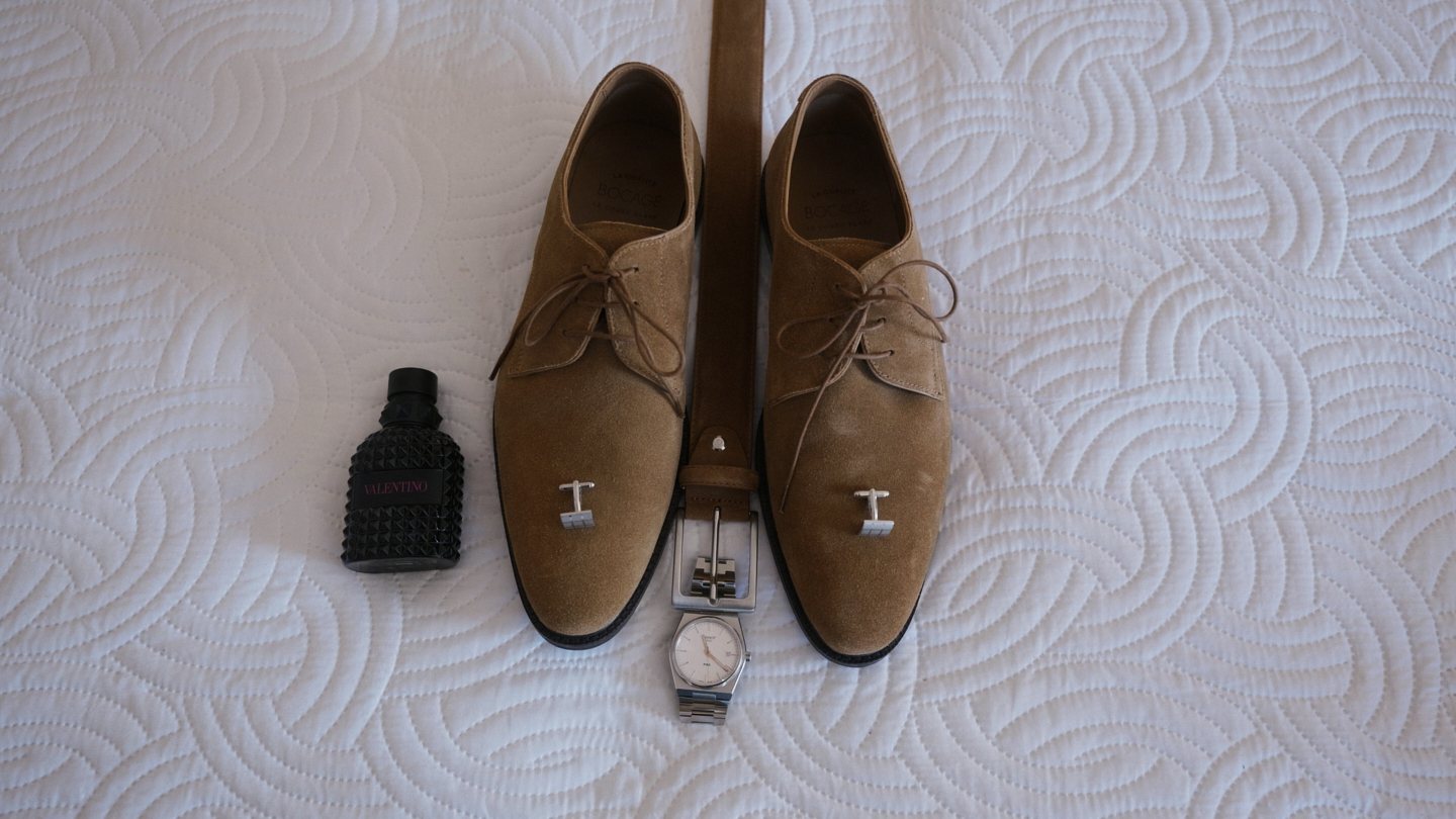 Sapatos, relógio e botões de punho pousados