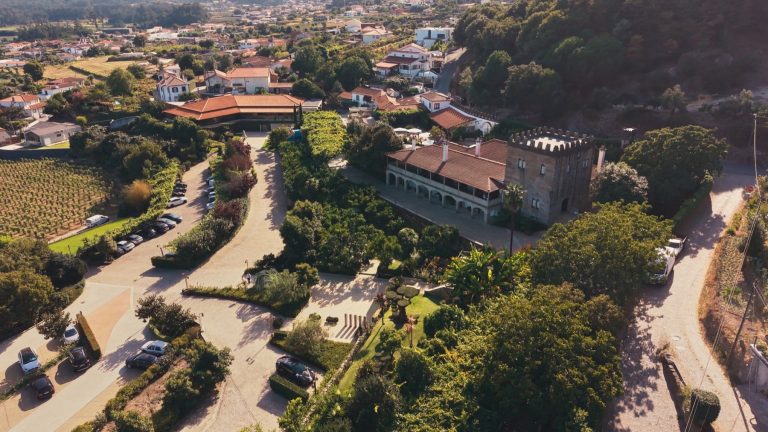 Vista aérea de uma quinta de casamentos do Minho, com o jardim e o casario à volta